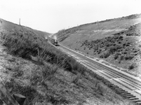 163252 Gezicht in de ingraving ter hoogte van Oosterbeek Hoog, met op de achtergrond een trein getrokken door een ...